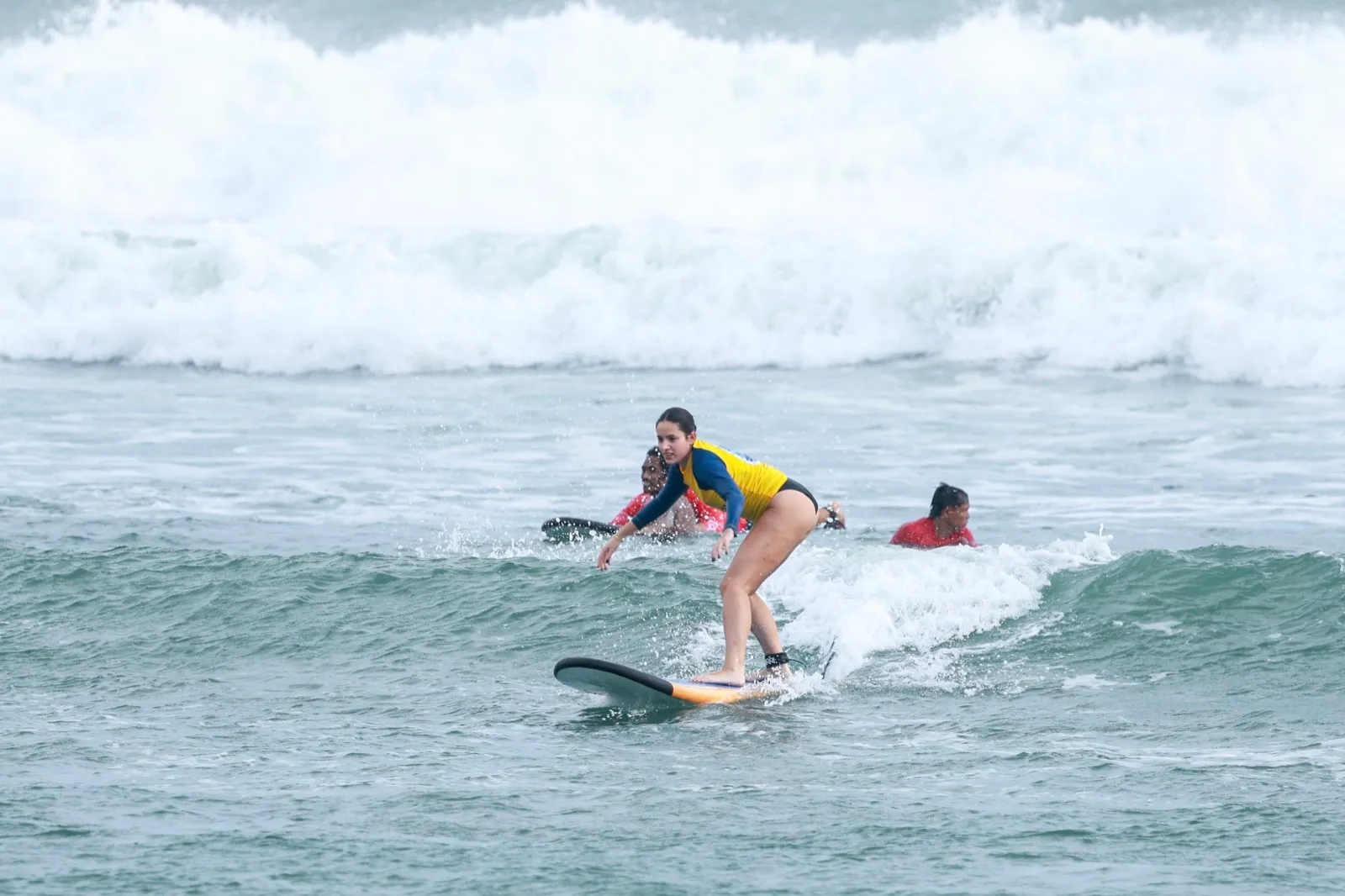Group of stoked students celebrating in the water after catching their waves