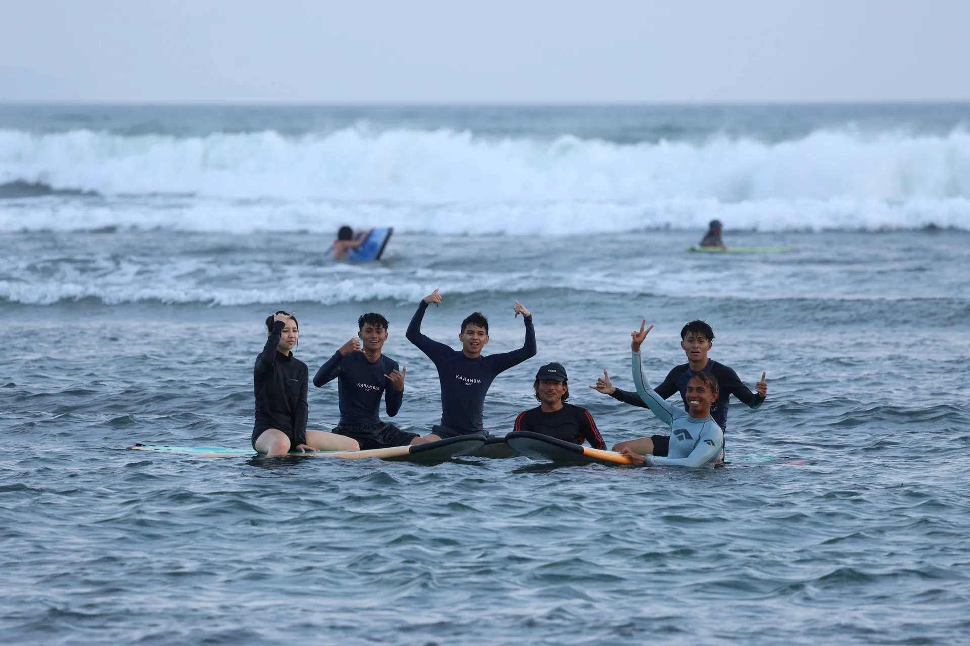 Group of stoked students celebrating in the water after catching their waves