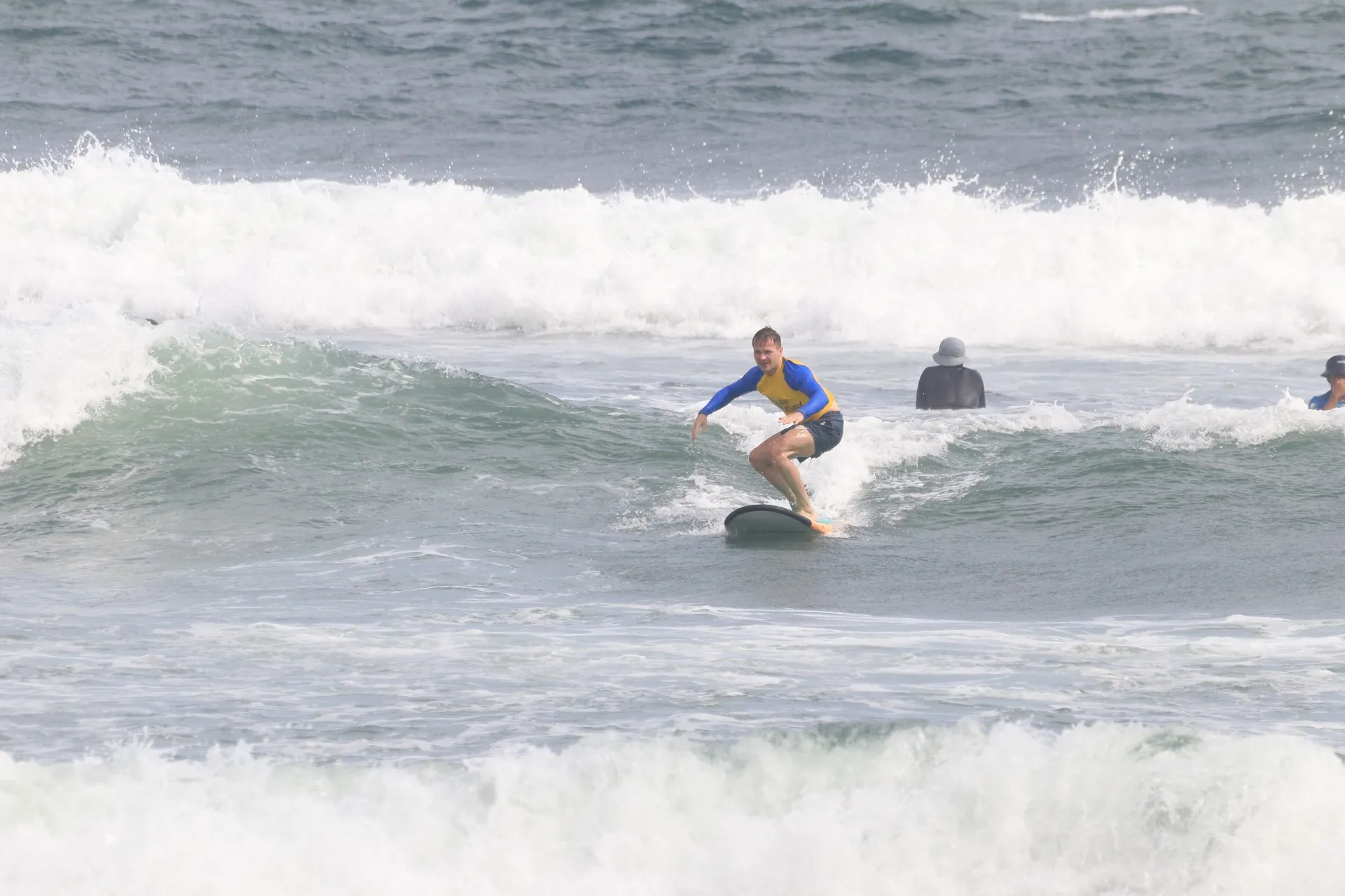 First-timer riding the white water all the way to the beach, grinning
