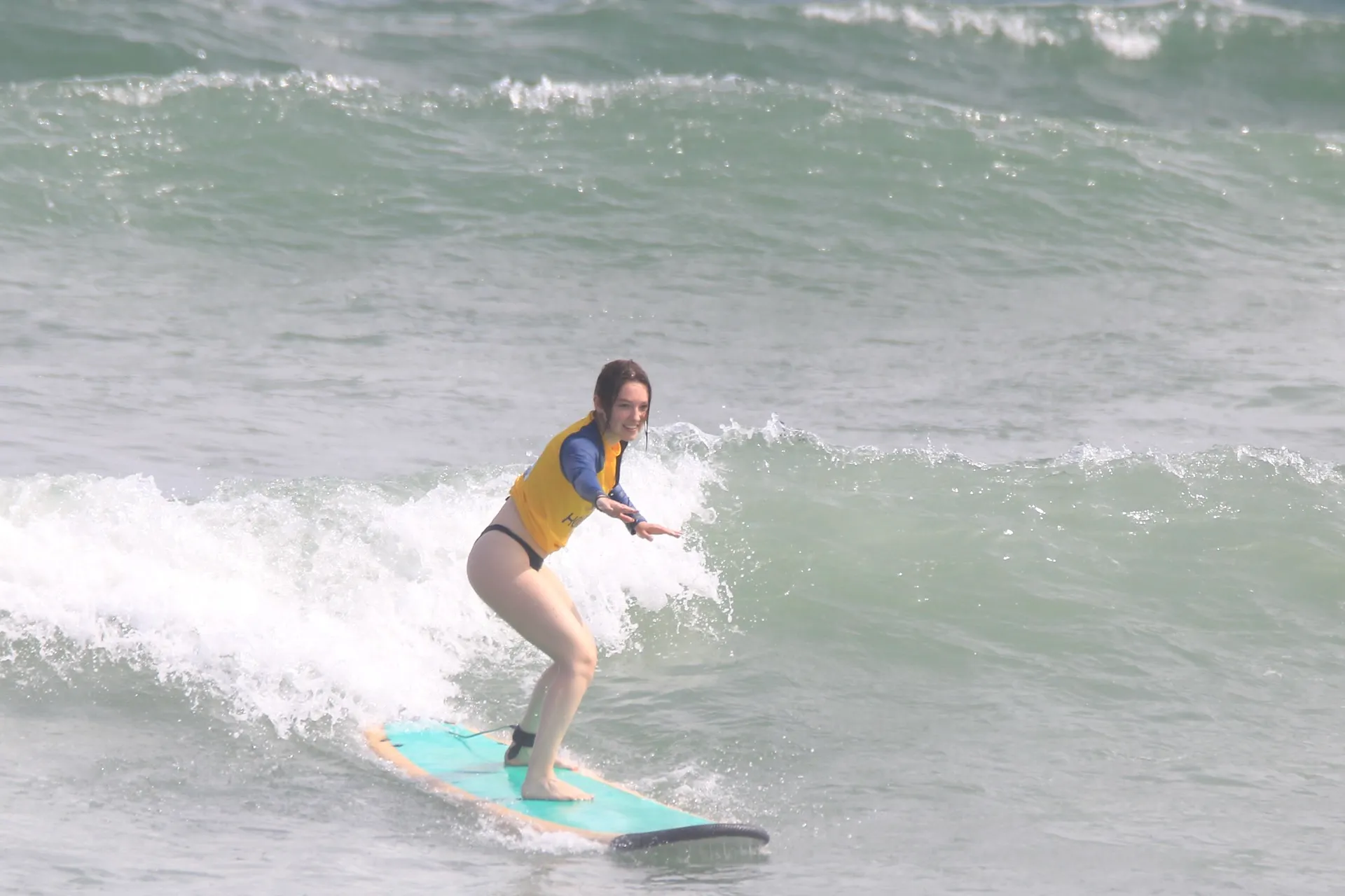 Surfers spread across gentle waves at Canggu beach through the day